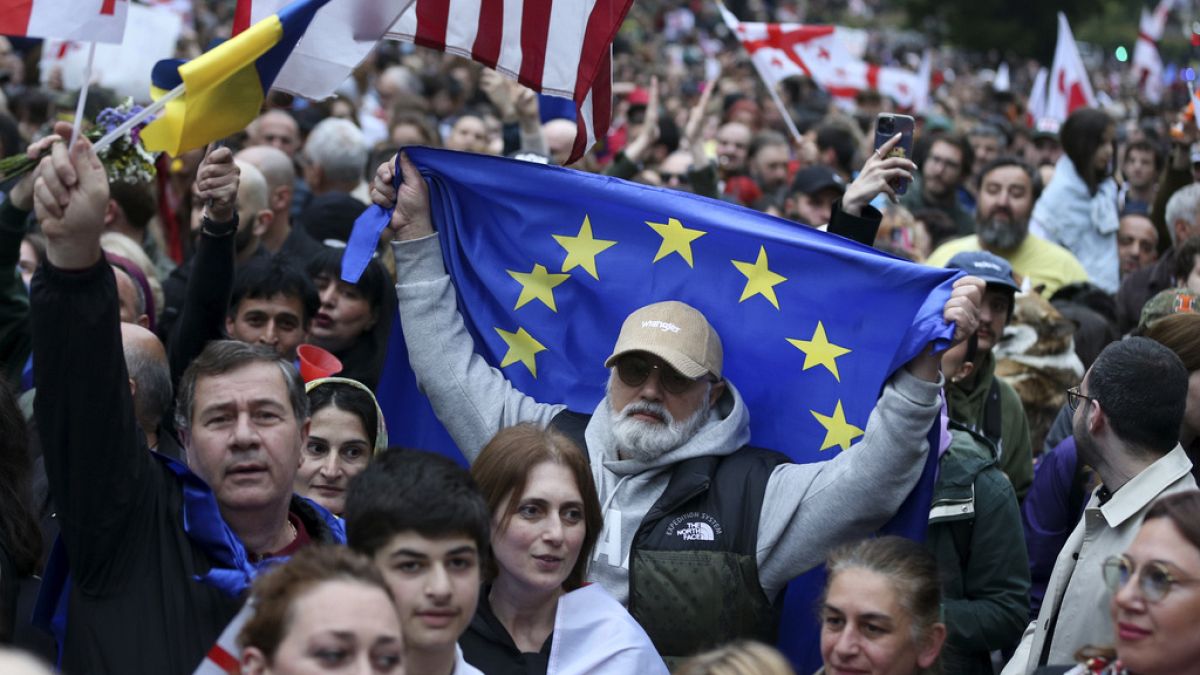 Des manifestants portant des drapeaux nationaux géorgiens se rassemblent lors d'une manifestation de l'opposition contre le projet de loi sur l'influence étrangère