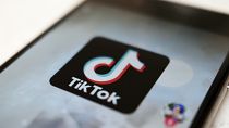The TikTok logo is displayed on a smartphone screen 