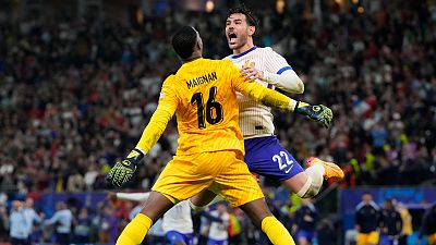 France's Theo Hernandez celebrates with his teammate Mike Maignan after scoring the decisive penalty against Portugal