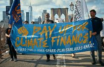 Protesters cross the Brooklyn Bridge during a Youth Climate Strike march to demand an end to the era of fossil fuels, 20 September 2024, in New York.