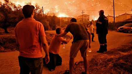 A resident reacts as a wildfire approaches the village of Ano Loutro as fanned by strong winds raged, 29 September 2024.