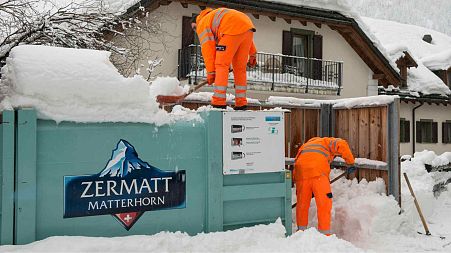 Community workers remove snow on and around a dump in Zermatt, Switzerland, Tuesday, Jan. 9, 2018.