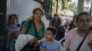 Greek citizens, who were evacuated from Lebanon with a Greek military transport aircraft stand outside the Greek Foreign ministry building in Athens, October 3, 2024