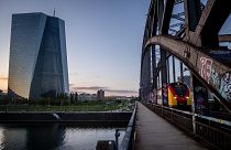 A train travels past the European Central Bank in Frankfurt, Germany