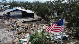 Helene Kasırgası sonrasında yıkılan belediye binasının üzerinde bir Amerikan bayrağı dalgalanıyor, Horseshoe Beach, Fla. 28 Eylül 2024.