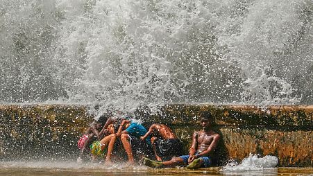 Youths duck behind the Malecon seawall as they play in the surf brought by Hurricane Milton passing through the Gulf of Mexico, in Havana, Cuba, Oct. 9, 2024. 