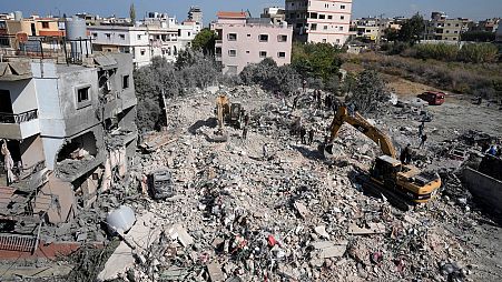 Rescue workers use excavators to clear the rubble of a destroyed building hit in an Israeli airstrike on Tuesday night, in Sarafand, southern Lebanon, Wednesday, Oct. 30, 2024