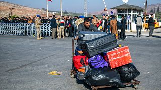 Syrians arrive to cross into Syria from Turkey at the Cilvegozu border gate, near the town of Antakya, southern Turkey, Monday, 9 December 2024.