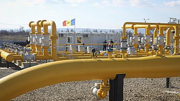 FILE - Men stand next to pipelines of the national natural gas distribution network outside Ungheni, Moldova, March 4, 2015. (AP Photo/Aurel Obreja)