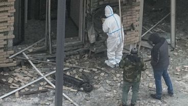 Investigators work near a scooter at the place where Lt. General Igor Kirillov and his assistant Ilya Polikarpov were killed, 17 December 2024.