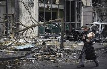 A woman walks past buildings destroyed by recent Russian attacks in Kyiv, 20 December, 2024