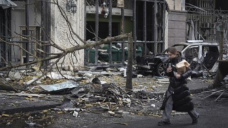 A woman walks past buildings destroyed by recent Russian attacks in Kyiv, 20 December, 2024