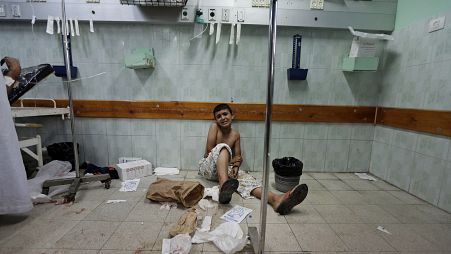 Un ragazzo palestinese ferito da un attacco israeliano siede sul pavimento del pronto soccorso dell'ospedale Kamal Adwan, 3 agosto 2014.