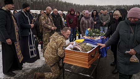 FILE - Funeral where serviceman Roman bids farewell to his comrade Serhii Solovyov who was killed in in Kursk, Russia. Irpin, Kyiv region, Ukraine, Nov. 21, 2024