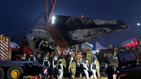 Una squadra di soccorso trasporta il corpo di un passeggero sul luogo dell'incendio di un aereo all'aeroporto internazionale di Muan a Muan, Corea del Sud, domenica 29 dicembre 2024.