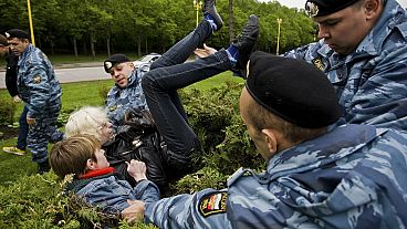 FILE - A Russian Gay Rights protester is taken away by riot police officers in Moscow, Russia, Saturday, May 16, 2009