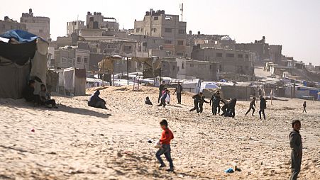 Des enfants jouent sur le sable dans un camp de déplacés palestiniens sur le front de mer à Deir al-Balah, au centre de la bande de Gaza, vendredi 27 décembre 2024.