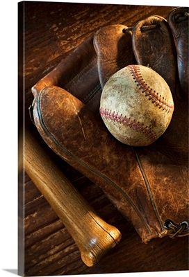 Antique baseball on baseball glove with bat