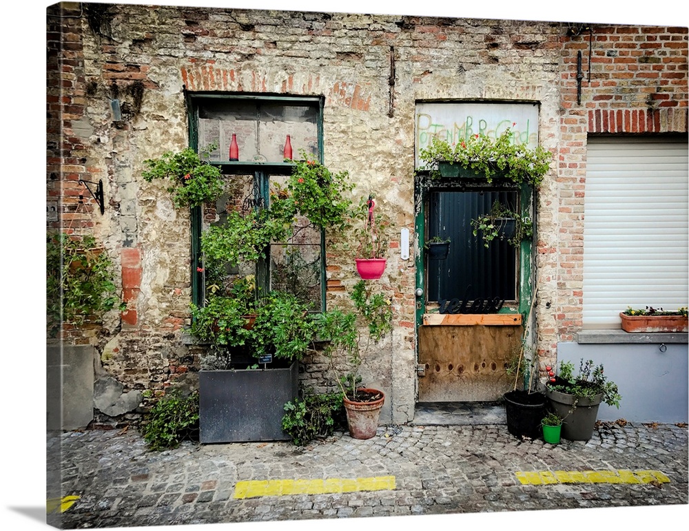 A photo of brick building covered in plants from a street view.