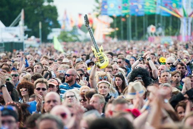 A festival goer holds an inflatable guitar at the Isle of Wight Festival, Seaclose park, Newport, on the Isle of Wight (David Jensen/PA)