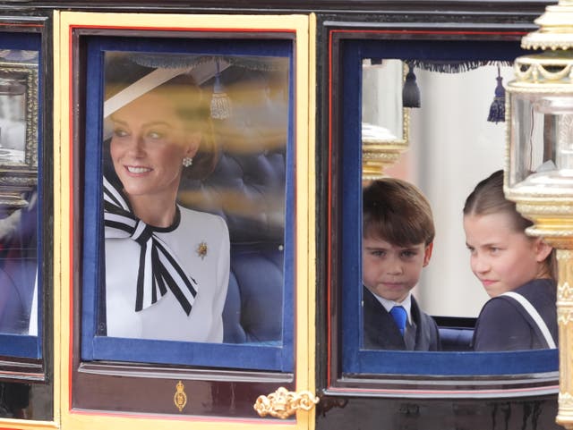 <p>Prince Louis and Princess Charlotte look out at the crowds while their mother smiles and waves </p>