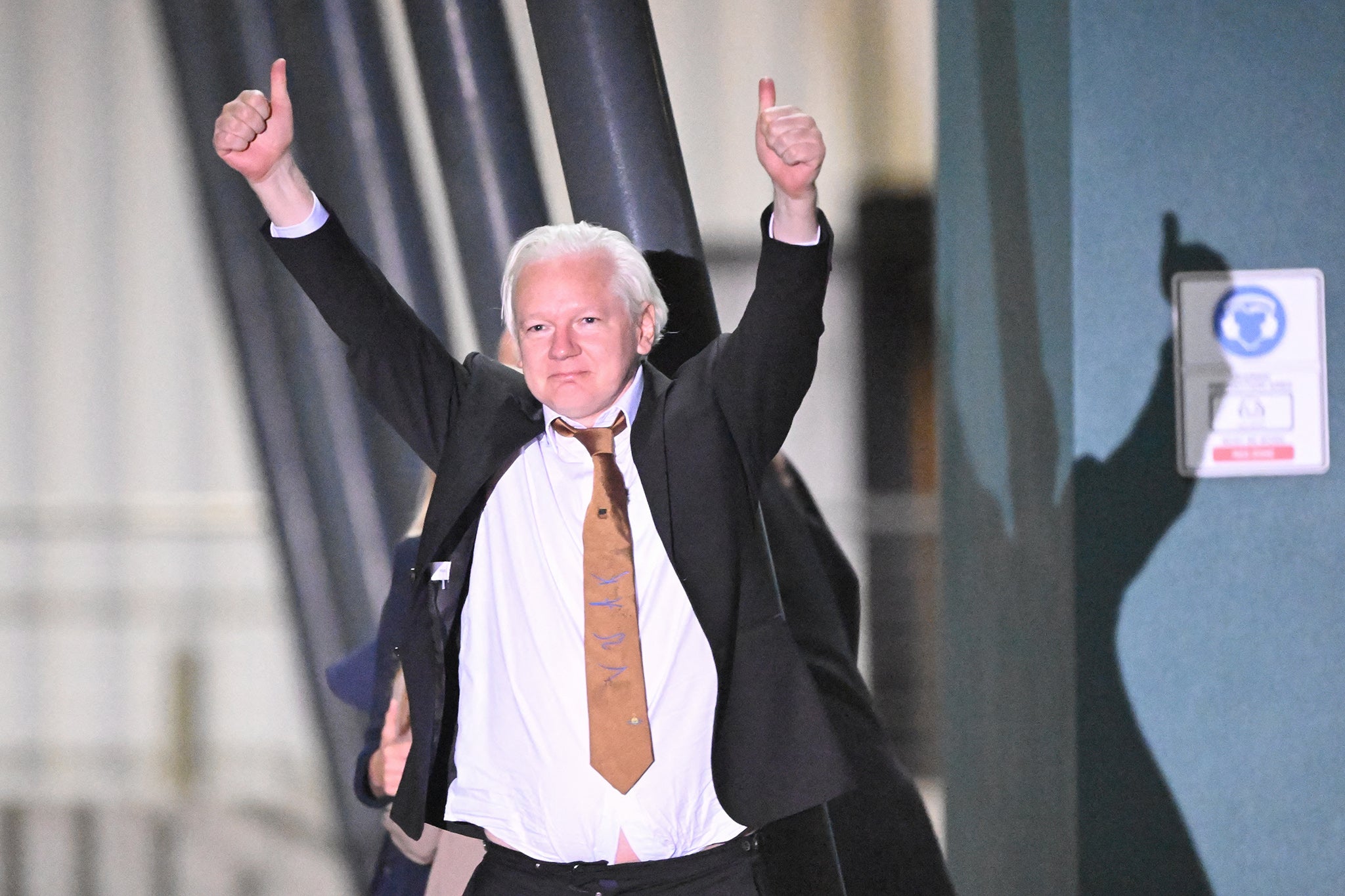 Julian Assange gives the thumbs up after arriving in Canberra on a charter plane from Saipan