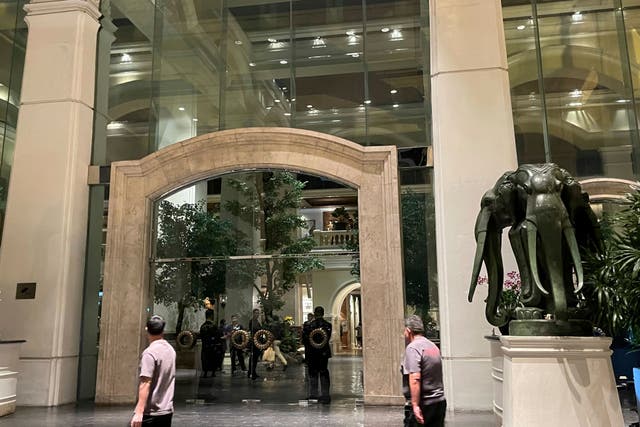 <p>Staff stand in the lobby of a hotel where a number of people were found dead in Bangkok, Thailand, Tuesday, July 16</p>