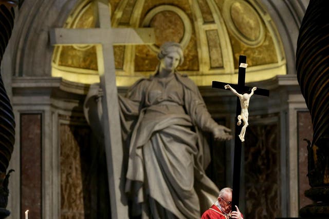 Pope Francis holds the Holy cross during the Celebration of the Lord's Passion at St. Peter's Basilica in Vatican City, Vatican on 14 April 2017