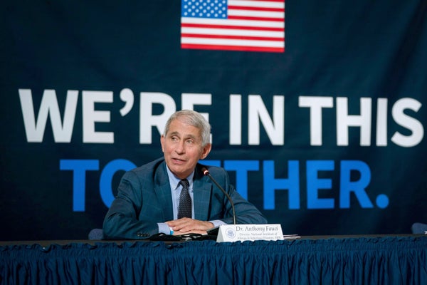 Dr. Anthony Fauci in front of backdrop that reads "We're in this Together"