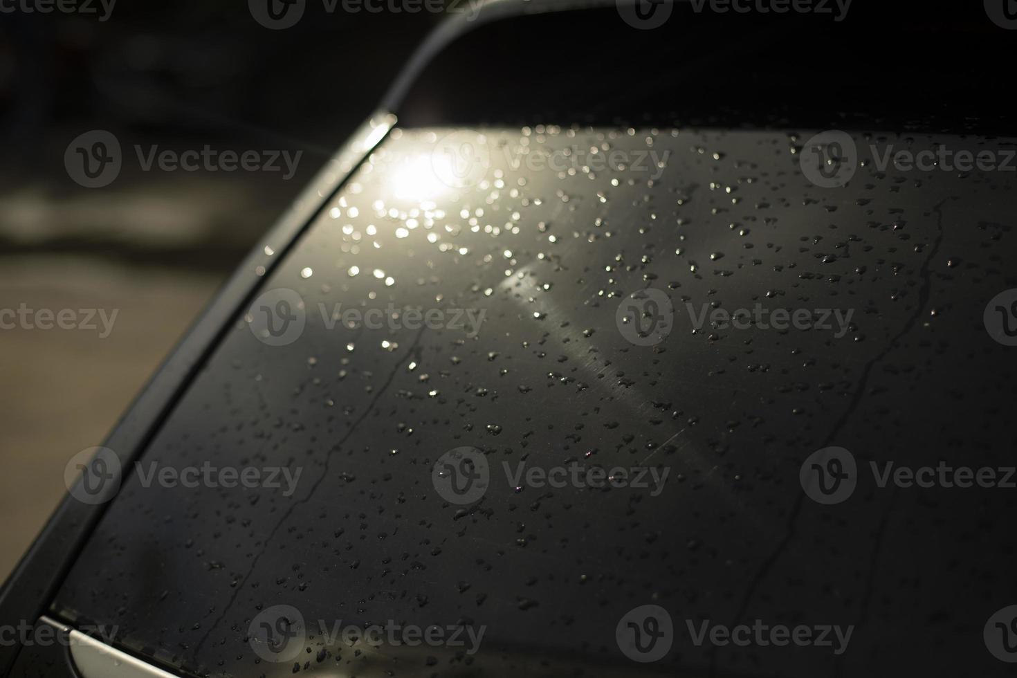 Black car rear window. Drops on rear window of transport. Light on car window. photo