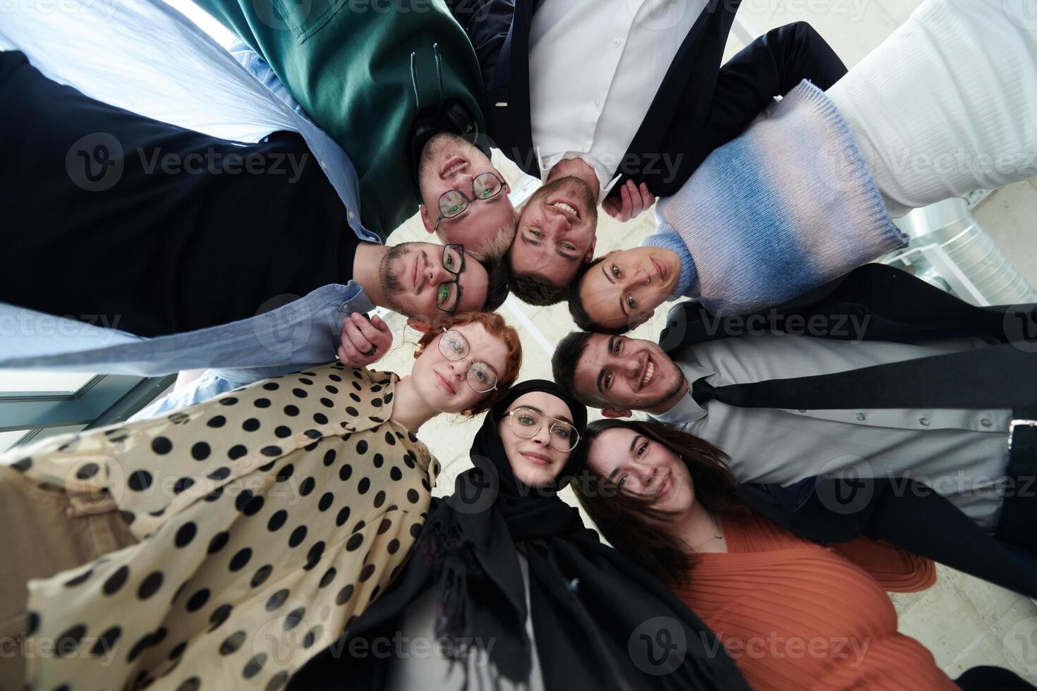 A diverse group of business professionals standing together in a powerful, united pose, captured from a low-angle perspective, exuding confidence and teamwork photo