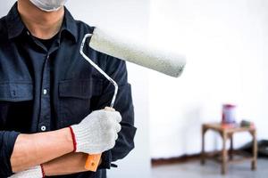 Male painter holding paint roller photo