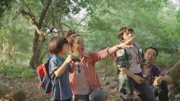 Asian parents bring two sons Hiking using binoculars For education Learn nature on vacation at the nature study center. video