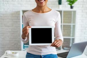 Closeup mockup image of black empty blank screen of tablet in the female hand, cropped image photo