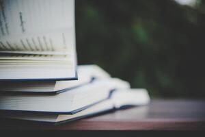 Open book on wooden table outdoors photo