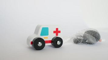 Close up of an ambulance toy pulling a heavy load stones. Conceptual for the efforts that health systems are doing during COVID photo