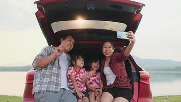 Happy family enjoying road trip on summer vacation. The family travels on the road in their favorite car. Holiday and travel family concept. video