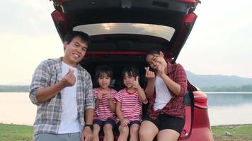 Happy family enjoying road trip on summer vacation. The family travels on the road in their favorite car. Holiday and travel family concept. video