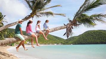 Young family on beach vacation on palmtree video