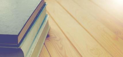 closeup books on brown wooden table for background photo