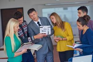 group of students working with teacher on  house model photo