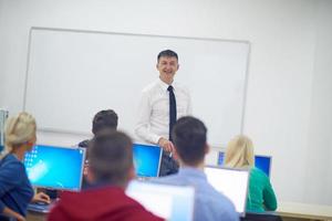 students with teacher  in computer lab classrom photo