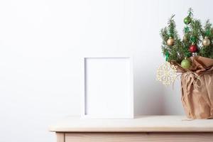 Zero waste Christmas natural decoration with rosemary as alternative Christmas tree and white mock up frame on table. Close up, copy space photo