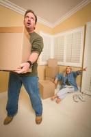 Stressed Man Moving Boxes for Demanding Wife photo