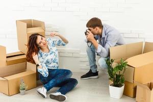 Smiling couple leaning on boxes in new home photo