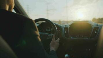 Man drives a car along the road, the setting sun shines in the windshield video