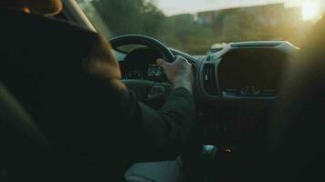 Man drives a car along the road, the setting sun shines in the windshield video