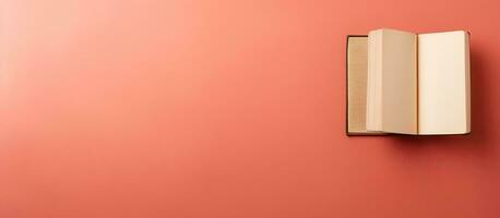 Photo of a closed red book against a vibrant red wall, offering a blank canvas for creative ideas with copy space