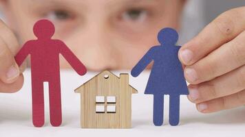 a person holding a paper cutout of a family with a house video