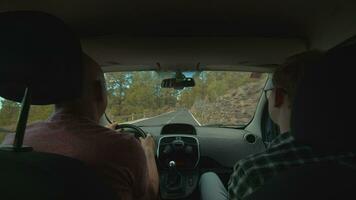 A view of a mountain road from a backseat of a moving car video